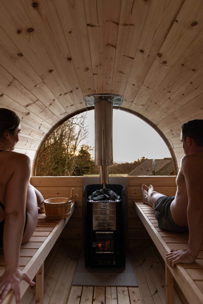 2 people sitting in log-burning Barend sauna